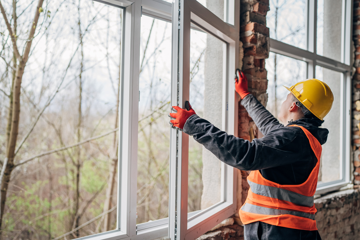 Craftsmen adjusting new windows on construction site